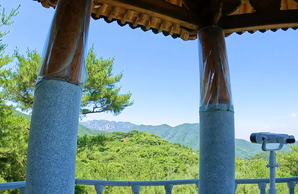 월명동 자연성전 별봉에 위치한 별봉정의 기둥 구조물과 산 정상 풍경